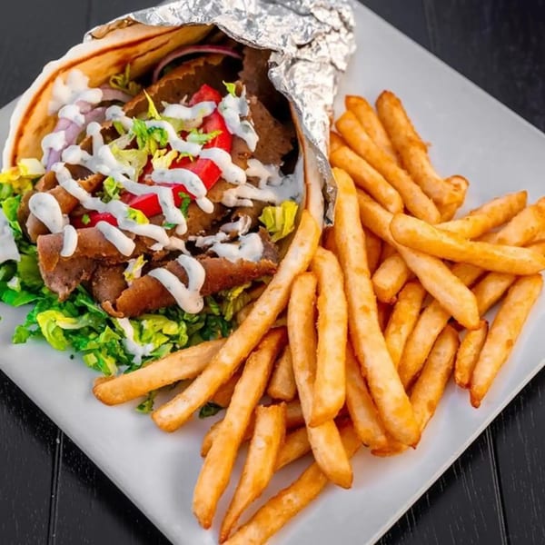 A Spiro's Taverna gyro with meat, lettuce, tomatoes, and tzatziki sauce, served with french fries.